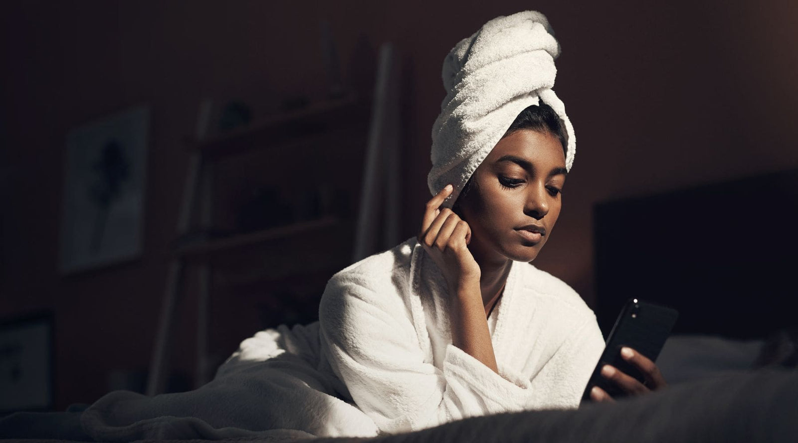 Woman on her bed about to use a jelly mask for her nightime skincare routine